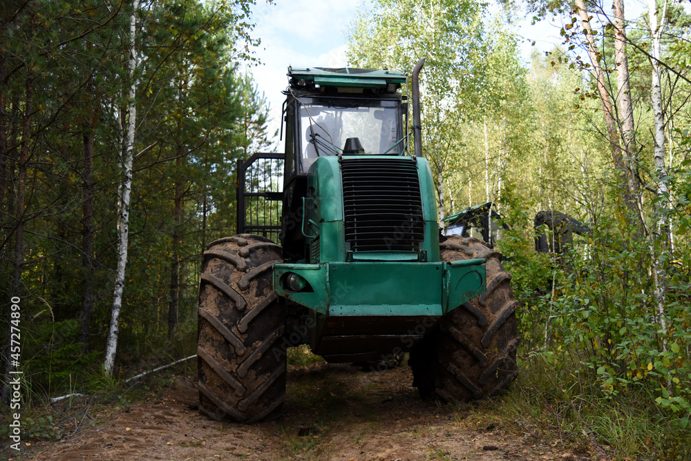 Crane forwarder machine during clearing of forested land. Wheeled harvester transports raw timber from felling site out. Harvesters, Forest Logging machines. Forestry forwarder on deforestation. Crane forwarder machine during clearing of forested land. Wheeled harvester transports raw timber from felling site out. Harvesters, Forest Logging machines. Forestry forwarder on deforestation.