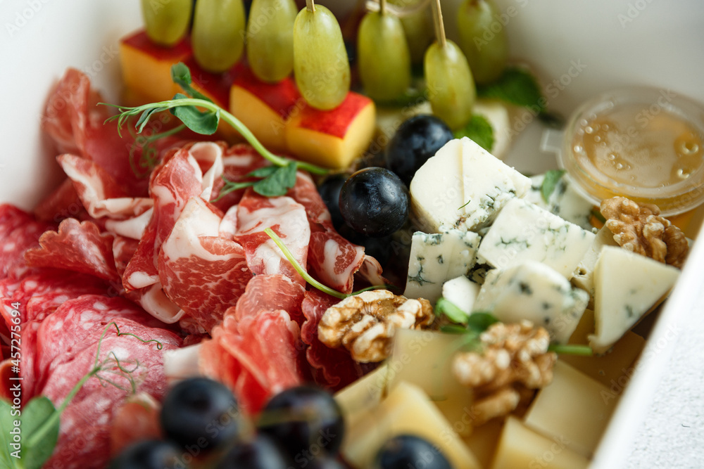 food box - a box with wine snacks. A set of canapes, cheese, parma, fruits and mini profiteroles. Set of food for a party, holiday or picnic
food box - a box with wine snacks. A set of canapes, cheese, parma, fruits and mini profiteroles. Set of food for a party, holiday or picnic