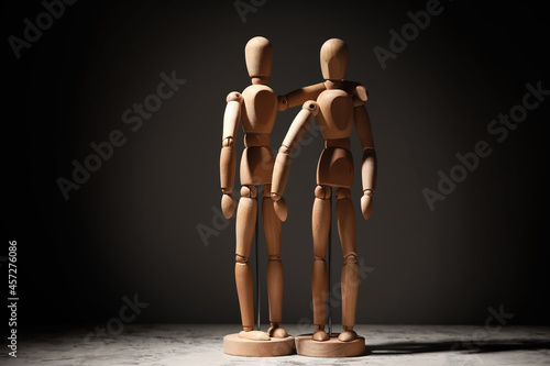 Wooden mannequins on dark b...