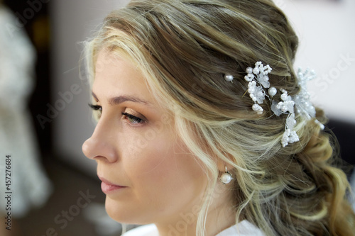 A beautiful bride in the morning with a hairstyle makeup after a visit to a makeup artist and stylist