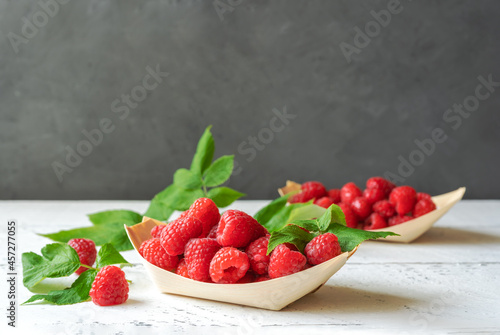 Raspberries in the wooden plates - boats with leaves