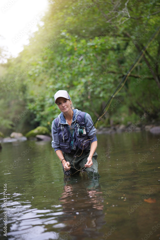 young woman fly fishing in a mountain river young woman fly fishing in a mountain river