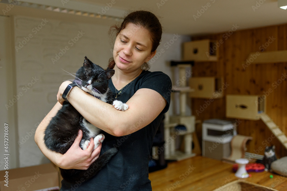 Woman Volunteer holding cat for adoption in animal shelter