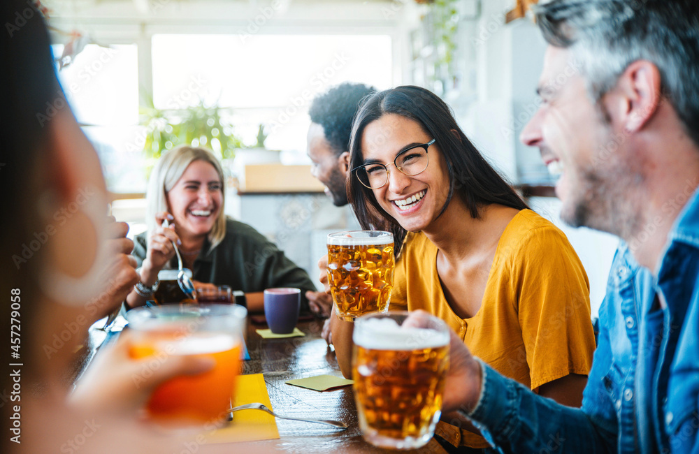 Young people dining having fun drinking beer at brewery pub - Happy friends laughing together talking on happy hour at cafe bar restaurant - Food, beverage and happy lifestyle concept Young people dining having fun drinking beer at brewery pub - Happy friends laughing together talking on happy hour at cafe bar restaurant - Food, beverage and happy lifestyle concept