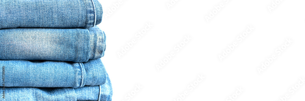 jeans are stacked on a white background. stack of several fashionable women's or teenage casual all-season denim pants clothing blue color. banner jeans are stacked on a white background. stack of several fashionable women's or teenage casual all-season denim pants clothing blue color. banner