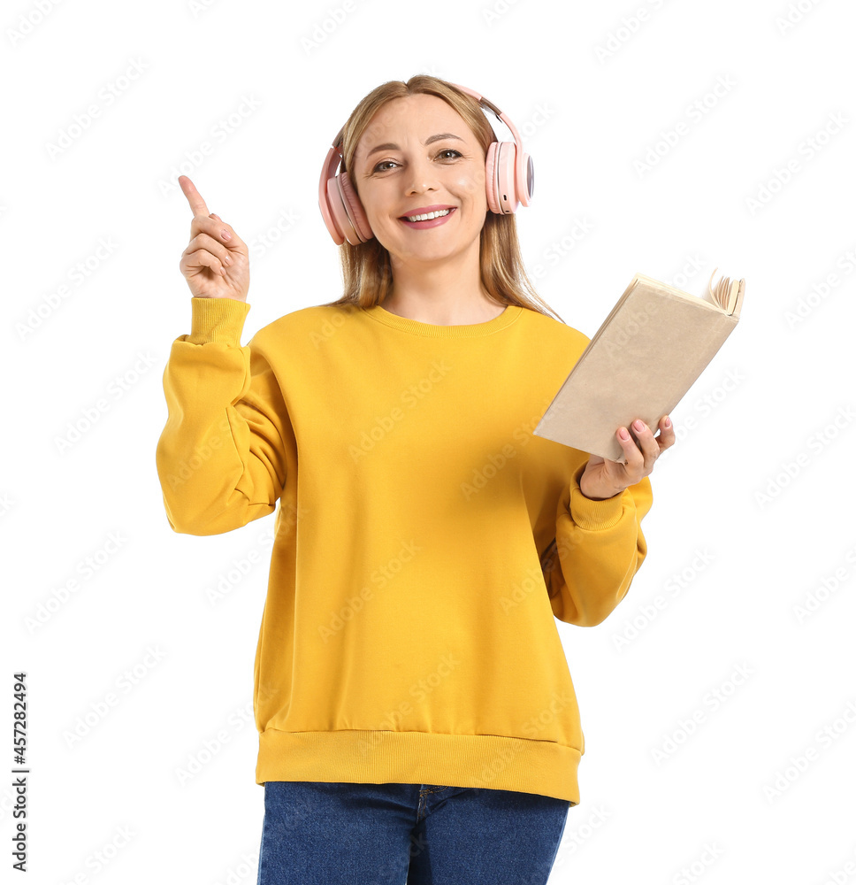 Mature woman with headphones reading book on white background Mature woman with headphones reading book on white background