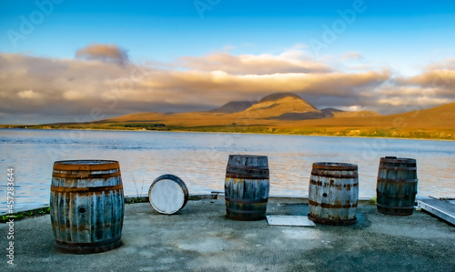 Photo Casks and Barrels in a Whiskey distillery Islay in Scotland coast with Jura behi