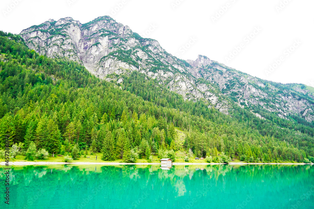 Heiterwanger See in Austria. View of the blue-green lake and the surrounding mountains. Landscape near Heiterwang. Heiterwanger See in Austria. View of the blue-green lake and the surrounding mountains. Landscape near Heiterwang.