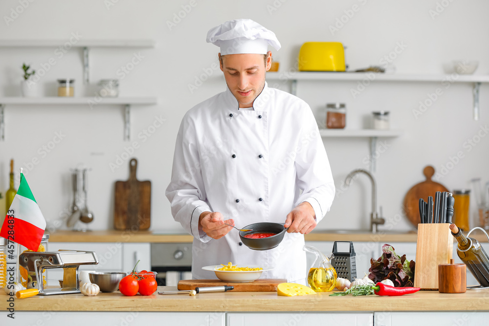 Italian chef pouring sauce into plate with pasta in kitchen Italian chef pouring sauce into plate with pasta in kitchen