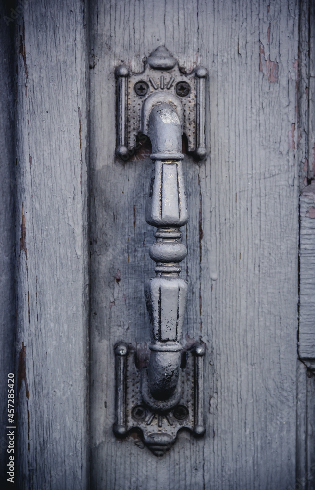 Old iron doorknob on a gray door. Wooden door and doorknob Old iron doorknob on a gray door. Wooden door and doorknob