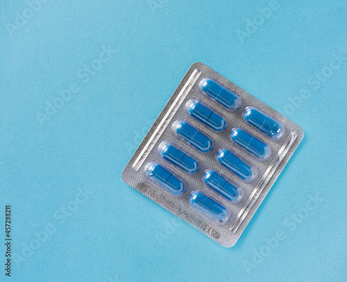 blister with pills, capsules of blue color on a blue background