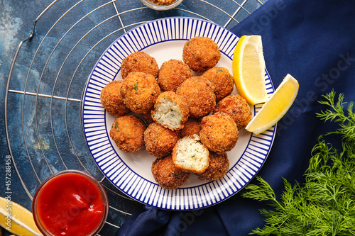Konstfotografi Plate with tasty cod cutlets and sauce on color background