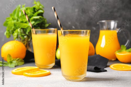 Glasses of tasty orange juice on table, closeup