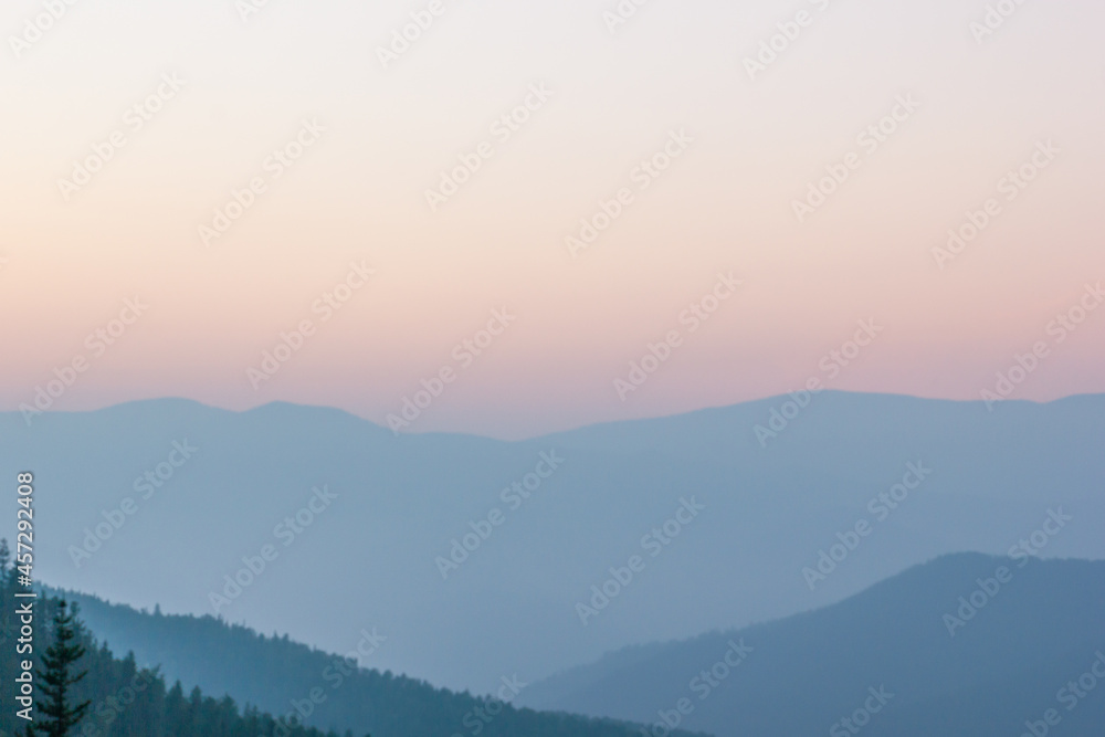 Blurred background smoky mountain landscape with mountain silhouette at sunset.