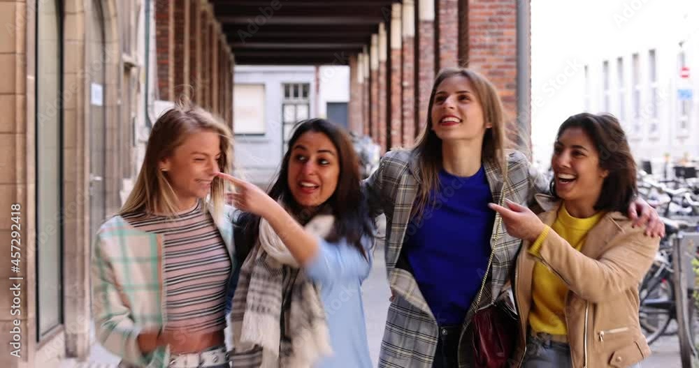 Lifestyle portrait of a diverse multiethnic group of attractive young woman friends talking together and smiling, having fun outside in a european city. High quality photo Lifestyle portrait of a diverse multiethnic group of attractive young woman friends talking together and smiling, having fun outside in a european city. High quality photo