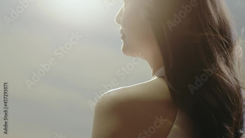 rear view of Asian beauty standing with long hair flying in wind