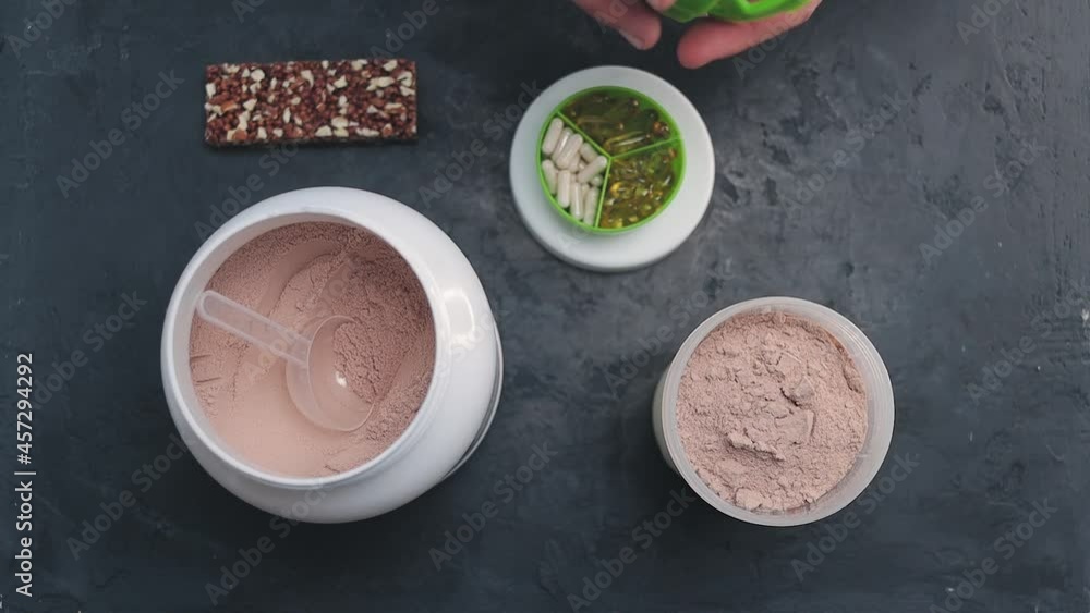 Process of making chocolate powder whey protein drink with milk in a shaker, slow motion, top view Process of making chocolate powder whey protein drink with milk in a shaker, slow motion, top view