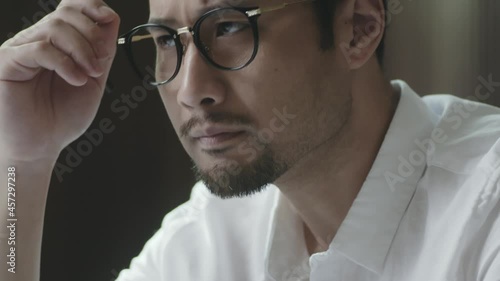 portrait of bearded Asian designer contemplating with hand on chin