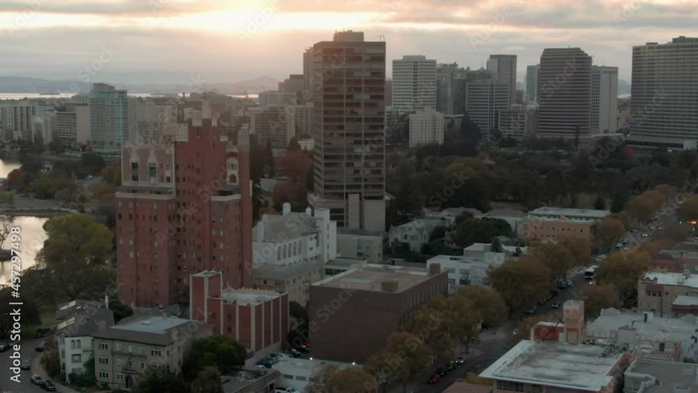 Aerial: Oakland City skyline & Lake Merritt at sunset