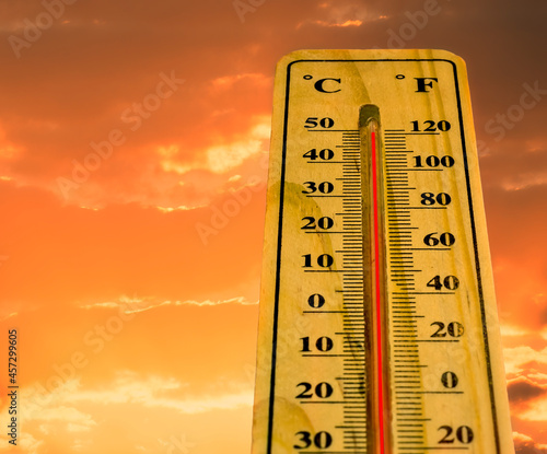Thermometer with extreme temperature and dramatic clouds. Conceptual image symbolizing a drastic climate changes on our planet 