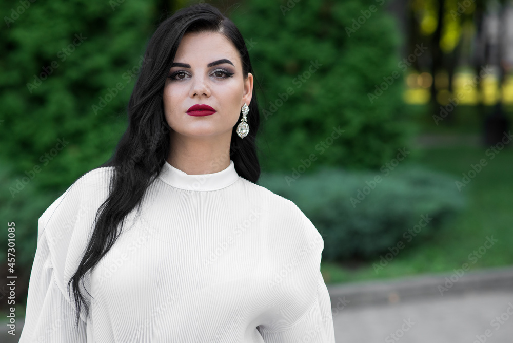 Portrait of a beautiful, young and attractive Caucasian brunette girl. Elegant girl posing in the summer in the park. Fashion concept. Portrait of a beautiful, young and attractive Caucasian brunette girl. Elegant girl posing in the summer in the park. Fashion concept.