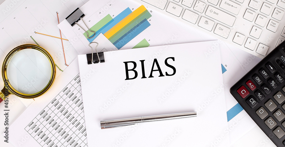 BIAS text on the white paper on the light background with charts paper ,keyboard and calculator