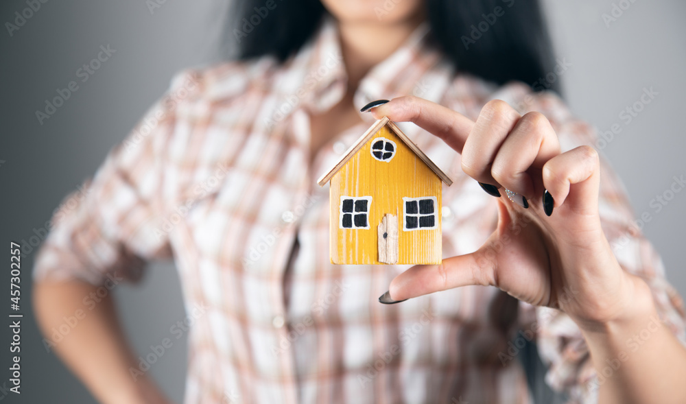 woman holding wooden house model woman holding wooden house model