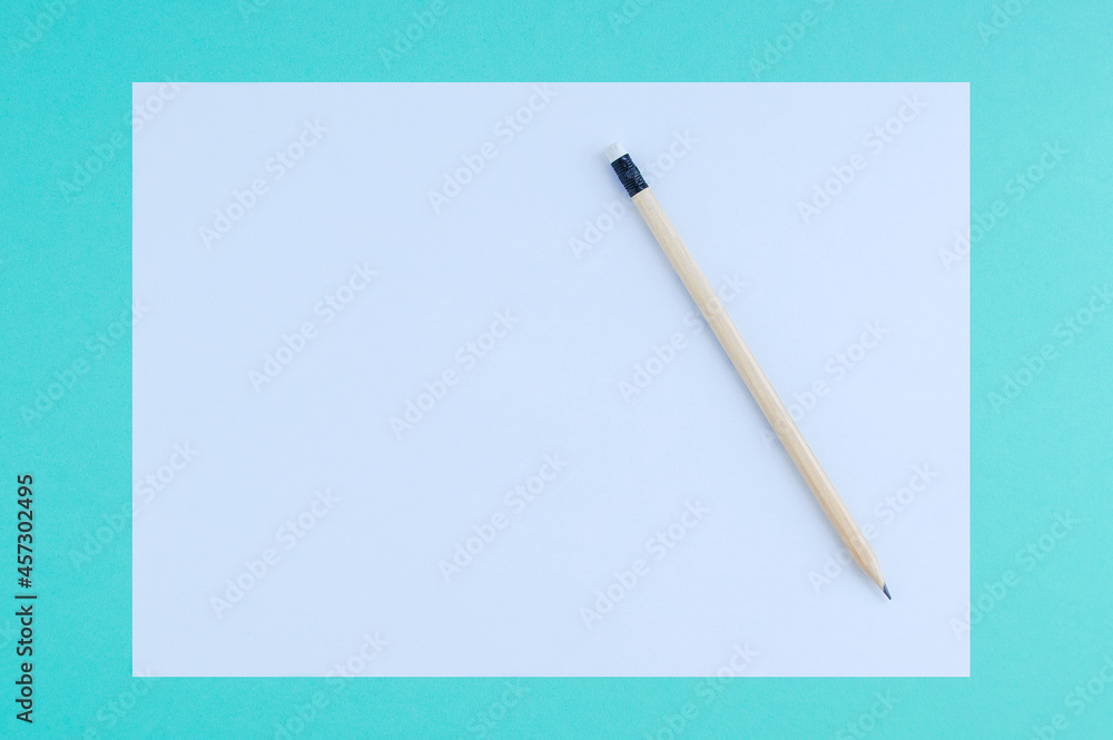 White sheet of paper and wooden pencil on turquoise background. White sheet of paper and wooden pencil on turquoise background.