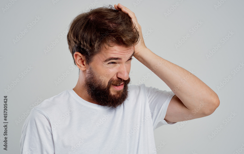 man holding his head pain stress emotions light background man holding his head pain stress emotions light background