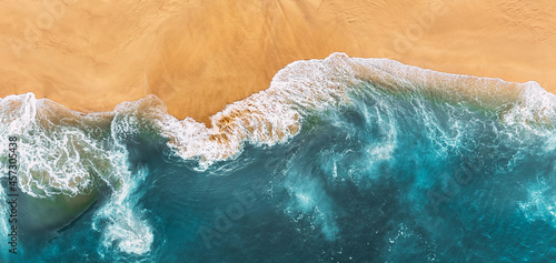 Sandy beach, panorama. Panoramic view of the sandy beach. The sea wave rolls on the shore. Sea coast view from the air. Aerial photography of the sea wave. The ocean and beach. Copy space photo