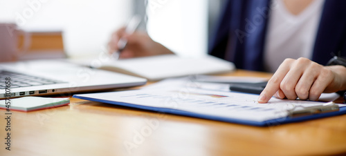 Close up of hand,Financial Businesswomen analyze the graph of the company's performance to create profits and growth, Market research reports and income statistics, Financial and Accounting concept.