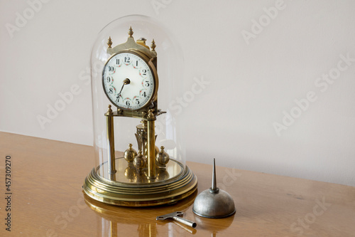 antique clock in glass dome, with oil pot and crown. Selective Focus Object.