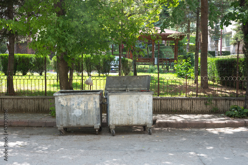 Garbage containers under trees on a roadside in Istanbul. Space for copy