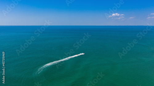 Summer water ride on a banana. Aerial view of a boat pulling an inflatable banana in the sea. Active beach vacation. © Сергей Теребов