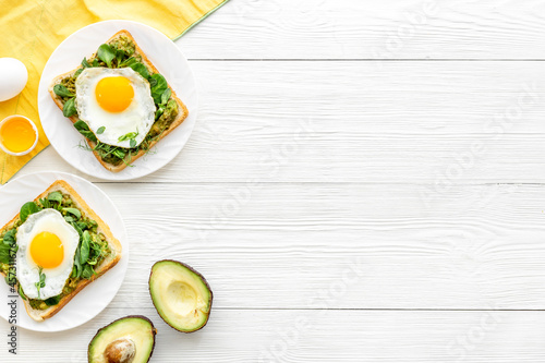Toasts with eggs and avocado cream and spinach. Top view