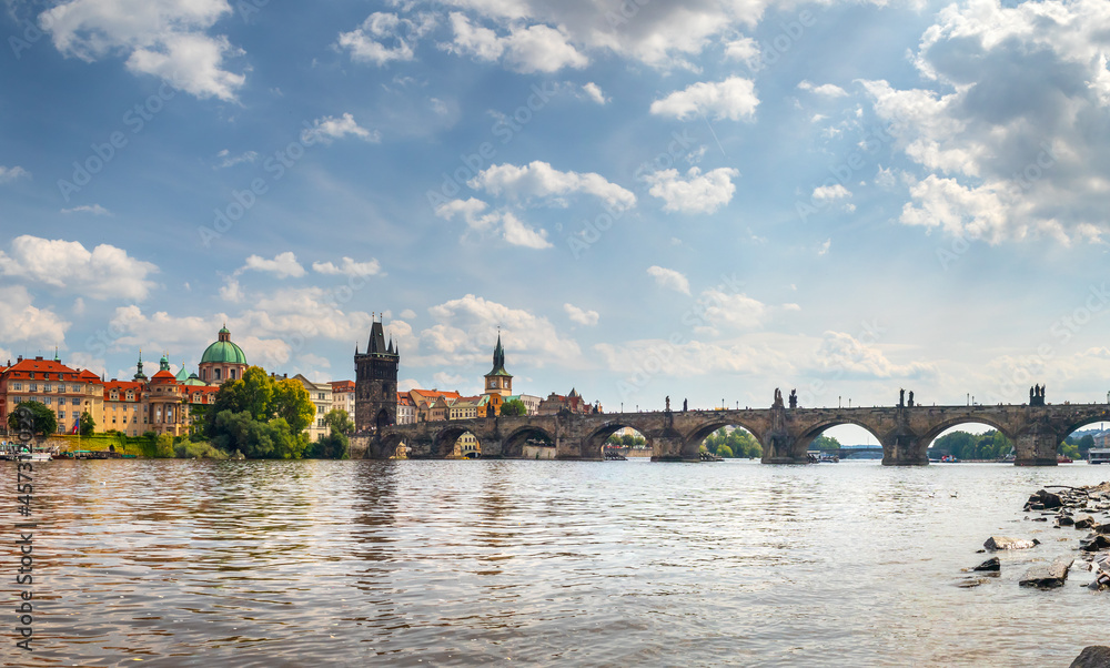 waterfront view across the river Vltava to the Charles Bridge and Old Town Bridge Tower, Prague, Czech republic