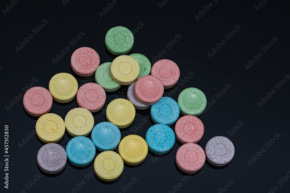 a bunch of 6 colored pills on black a bunch of 6 colored pills on black