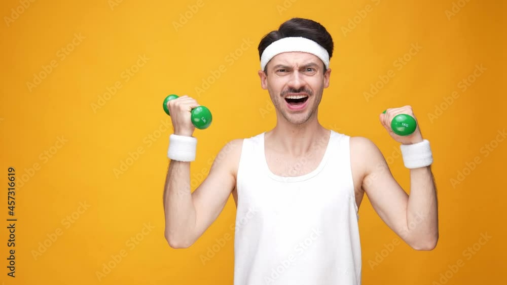 Charismatic strong guy lift little dumbbells make effort Charismatic strong guy lift little dumbbells make effort