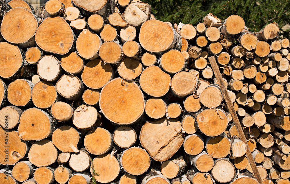 two woodpiles - one after the other small and large firewood two woodpiles - one after the other small and large firewood