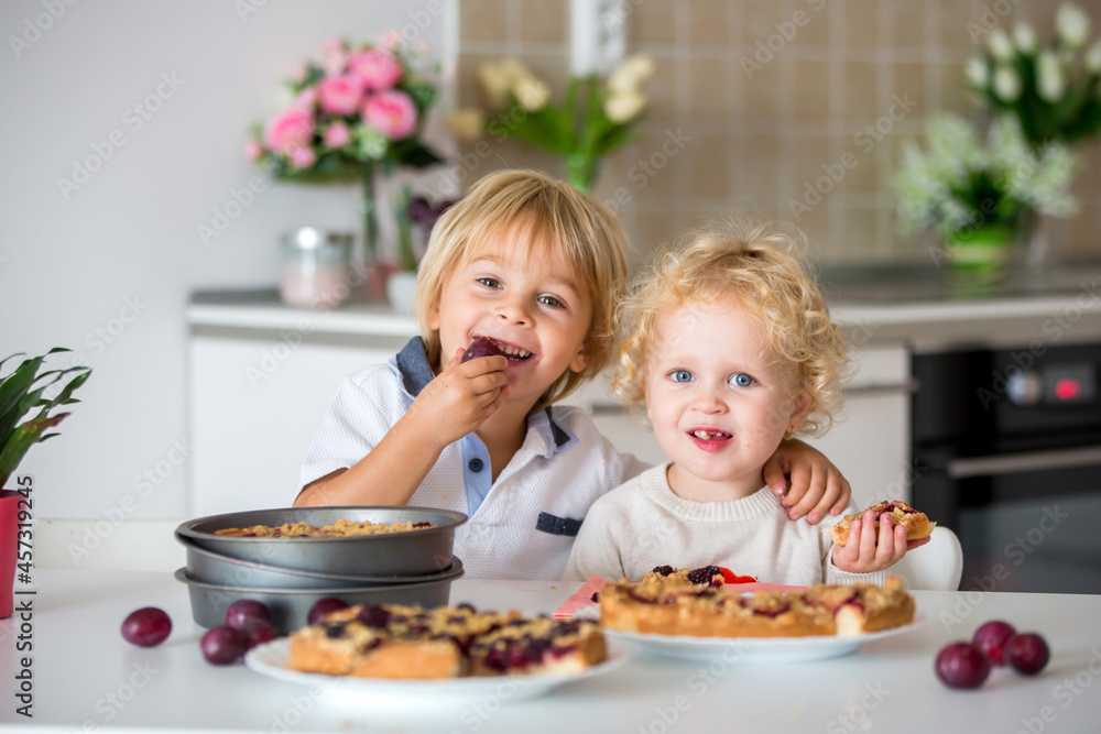 Cute little toddler child, eating homemade plum pie at home Cute little toddler child, eating homemade plum pie at home