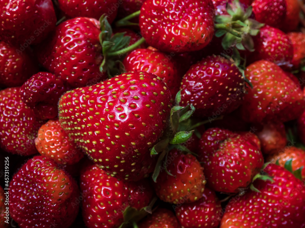 Macro shot of detailed, red, ripe strawberries with green leaves. Fruit and food background Macro shot of detailed, red, ripe strawberries with green leaves. Fruit and food background