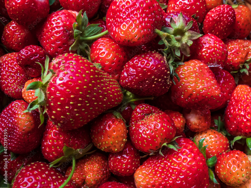 Macro shot of detailed, red, ripe strawberries with green leaves. Fruit and food background Macro shot of detailed, red, ripe strawberries with green leaves. Fruit and food background