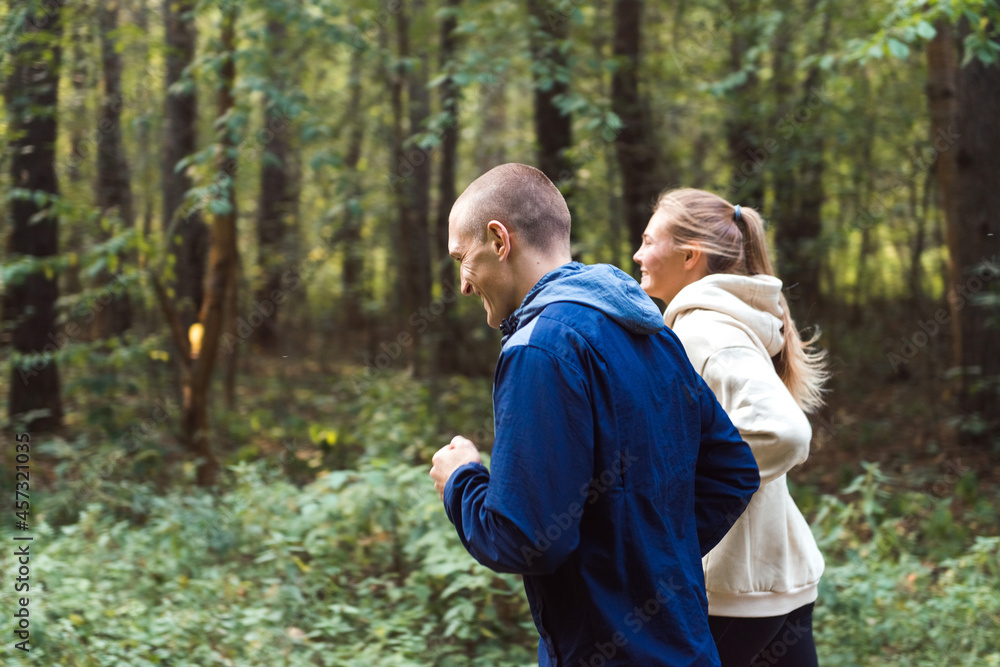 people running in forest, young man and woman jogging in park people running in forest, young man and woman jogging in park