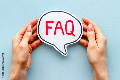 Hands with faq word on paper bubble. Frequently asked questions concept