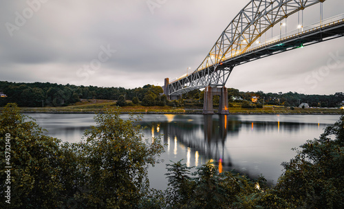 Tranquil seascape over the Cape Cod Canal with lighted Sagamore Bridge at dawn photo