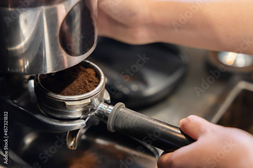 Barista Using Coffee Grinder to Make Fresh Roasted Coffee Powder