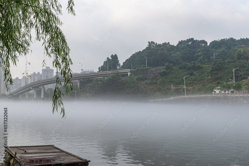 The scenery on both sides of the river in the morning fog