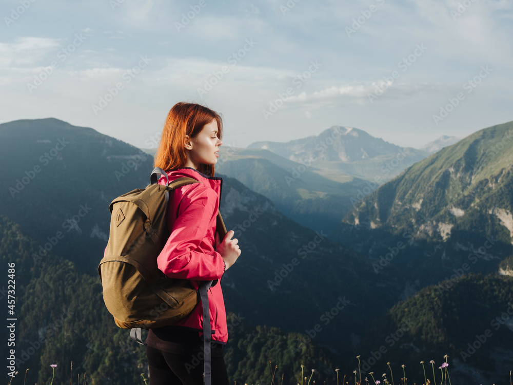 woman tourist with a backpack outdoors in the mountains fresh air