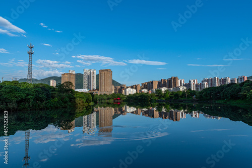 A city surrounded by lakes and forests, under the blue sky