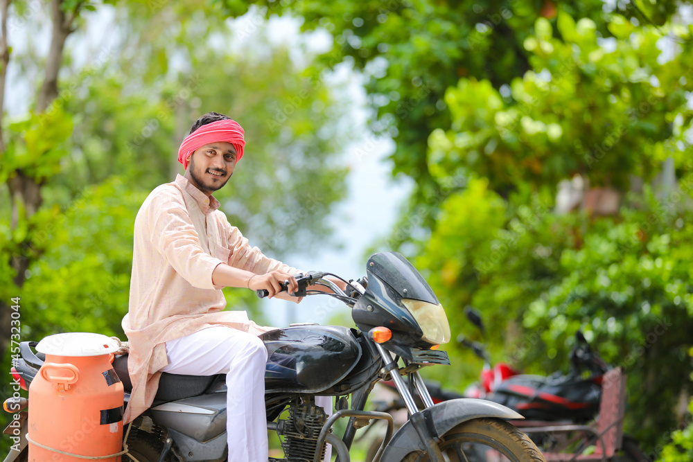 Rural scene : Indian milkman distribute milk on bike Rural scene : Indian milkman distribute milk on bike
